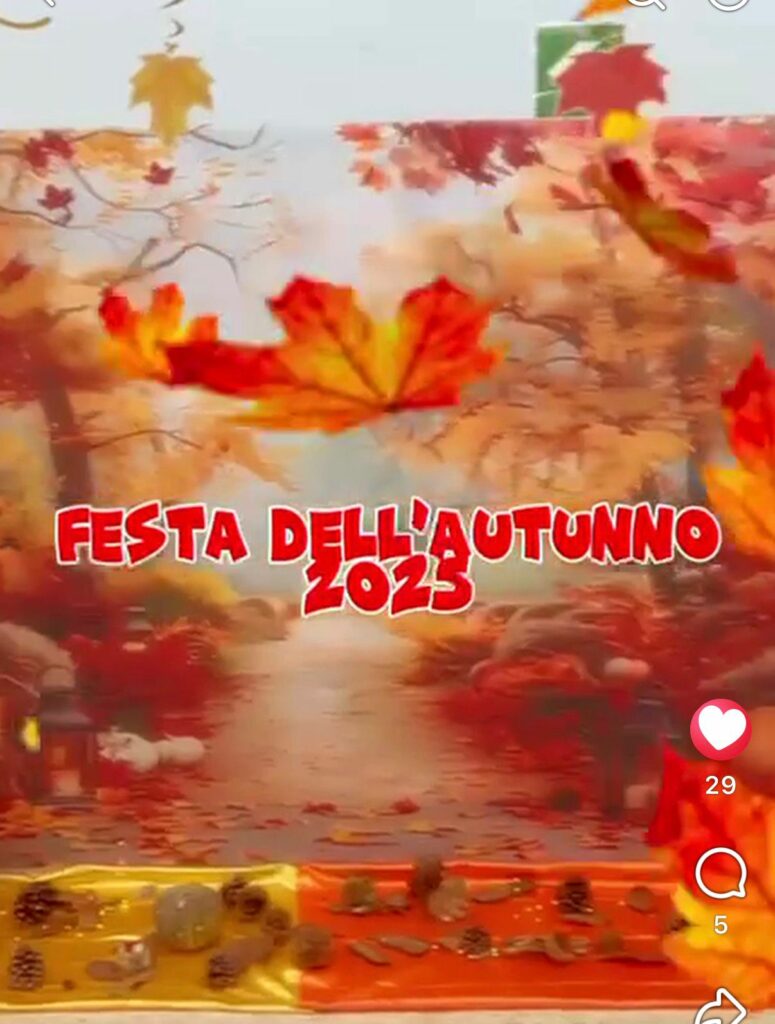 Cartellone colorato con la scritta 'Festa dell'Autunno 2023' su uno sfondo di bosco autunnale con foglie rosse e gialle, decorato alla base con pigne ed elementi naturali.