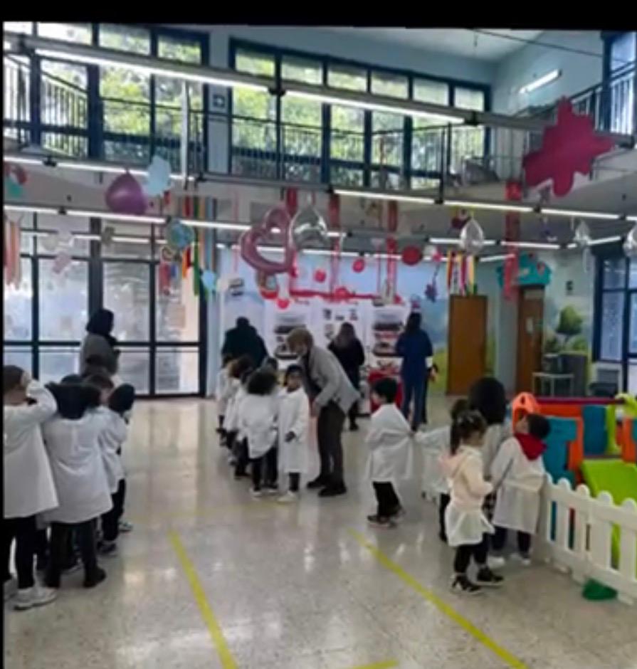 I piccoli alunni disposti in fila con il grande pannello della Nutella sullo sfondo