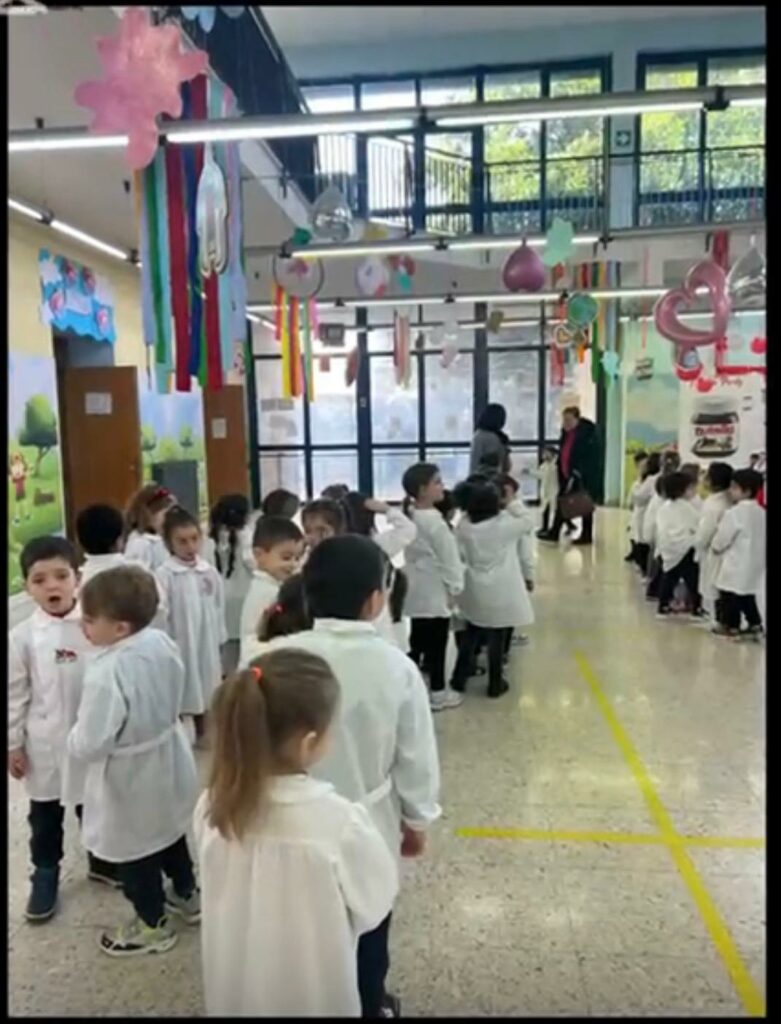 I piccoli alunni disposti in fila con il grande pannello della Nutella sullo sfondo